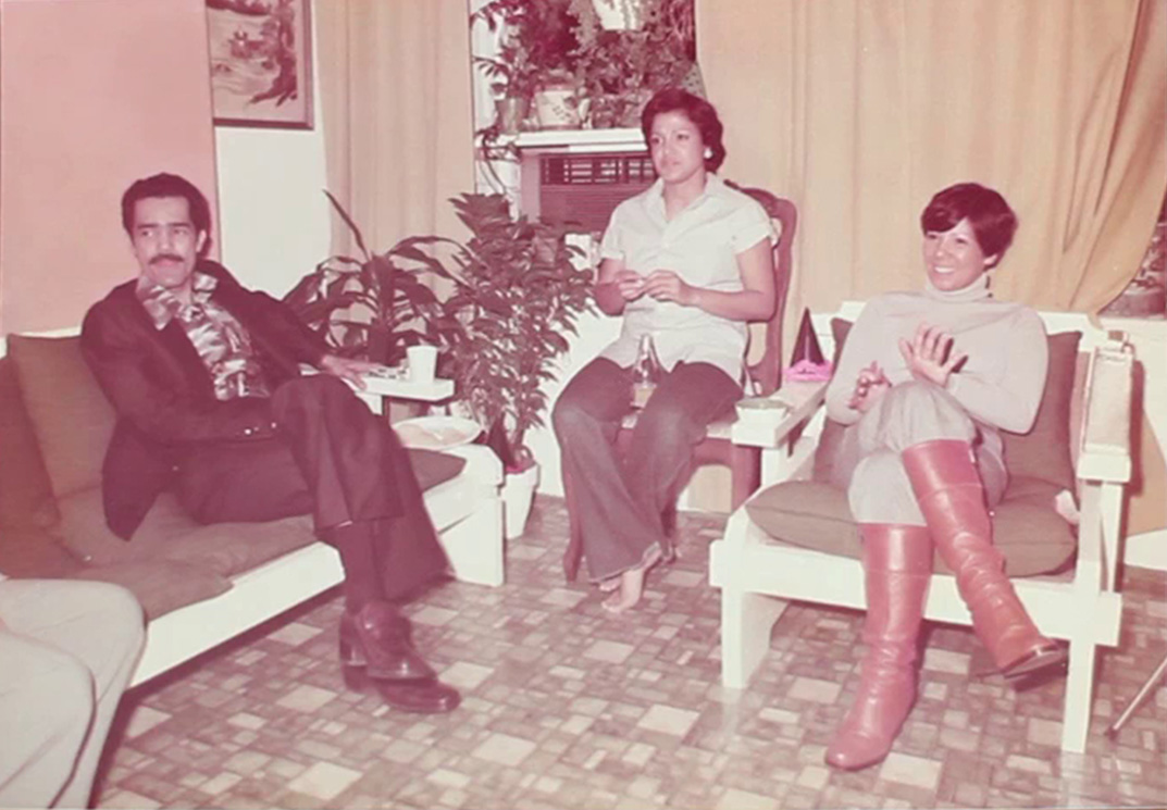 Three people, one man and two women, sitting in a living room looking away from the camera.