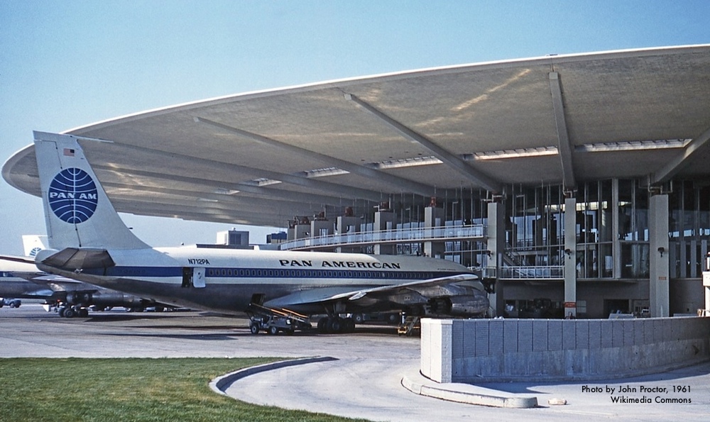 Pan American plane docked at JFK Airport on a sunny day.