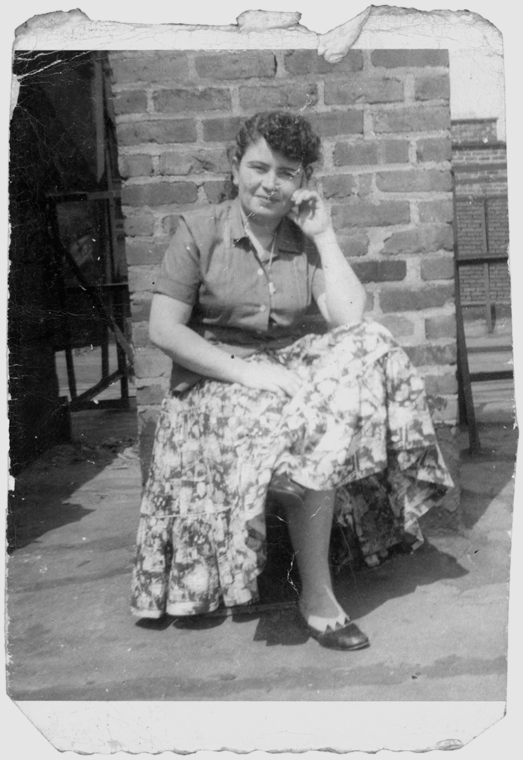 Ramonita Saez sitting on a rooftop with her hand on her cheek.